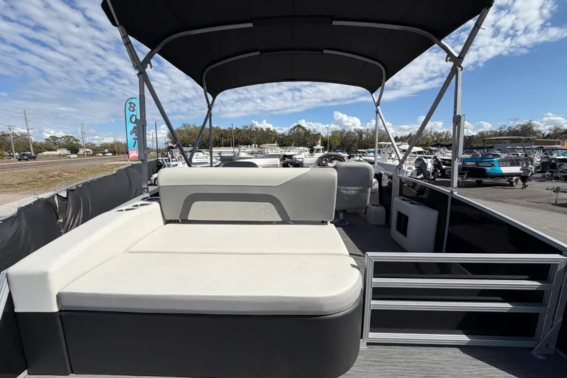 Slide: The Image of 2023 Lowe SS 210 pontoon boat with spacious seating and canopy, displayed outdoors. - 13