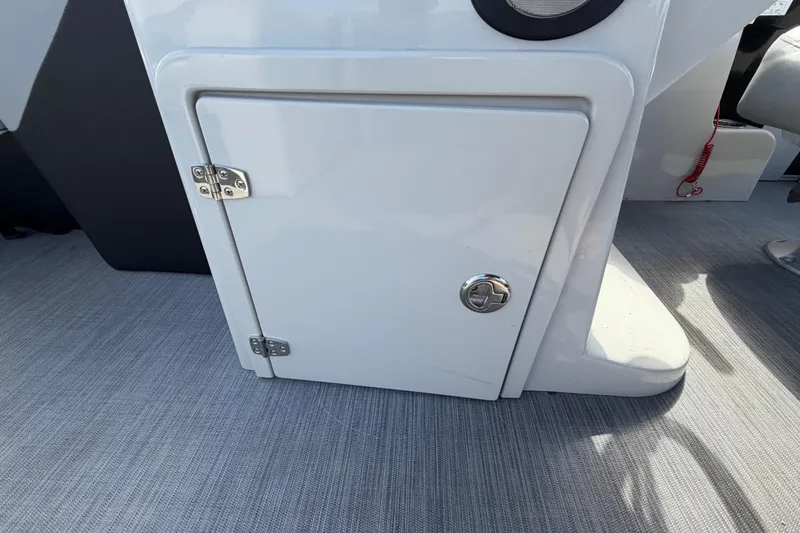 Slide: The Image of 2023 Lowe SS 210 boat storage compartment with secure latch on deck. - 26