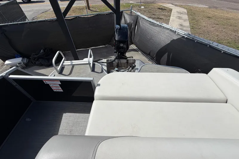 Slide: The Image of 2023 Lowe SS 210 pontoon boat interior with seating and motor view. - 43