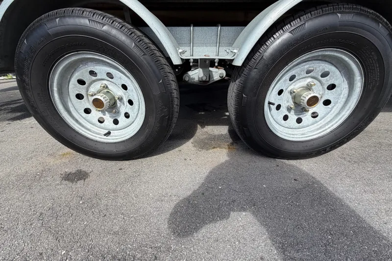 Slide: The Image of Dual wheels of a 2023 Lowe SS 210 trailer on asphalt pavement. - 49