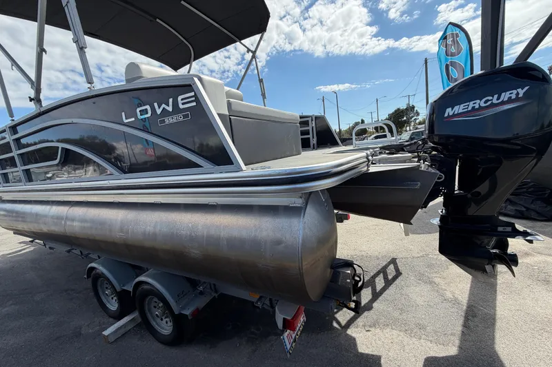 Slide: The Image of 2023 Lowe SS 210 pontoon boat with Mercury outboard motor on trailer. - 7