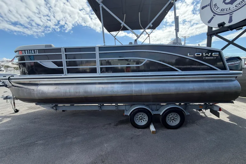 Slide: The Image of 2023 Lowe SS 210 pontoon boat on trailer under a partly cloudy sky. - 8