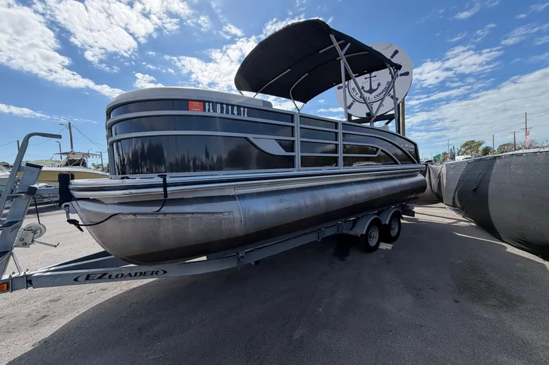 Slide: The Image of 2023 Lowe SS 210 pontoon boat on trailer under blue sky. - 9