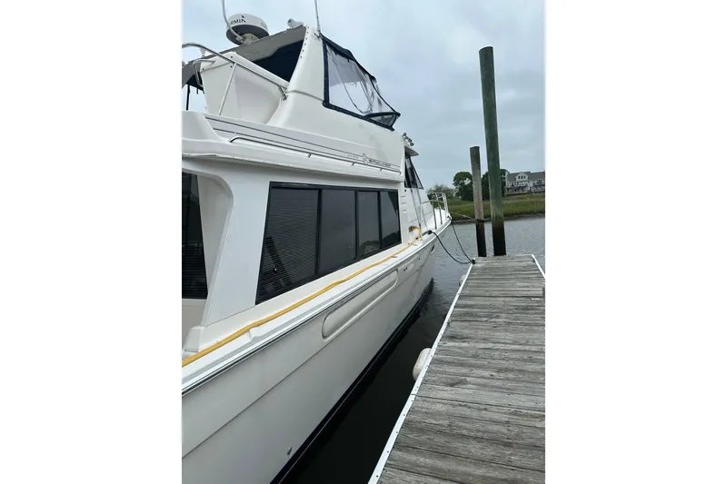 Slide: The Image of 1999 Bayliner 4788 Pilot House Motoryacht docked at a marina. - 14
