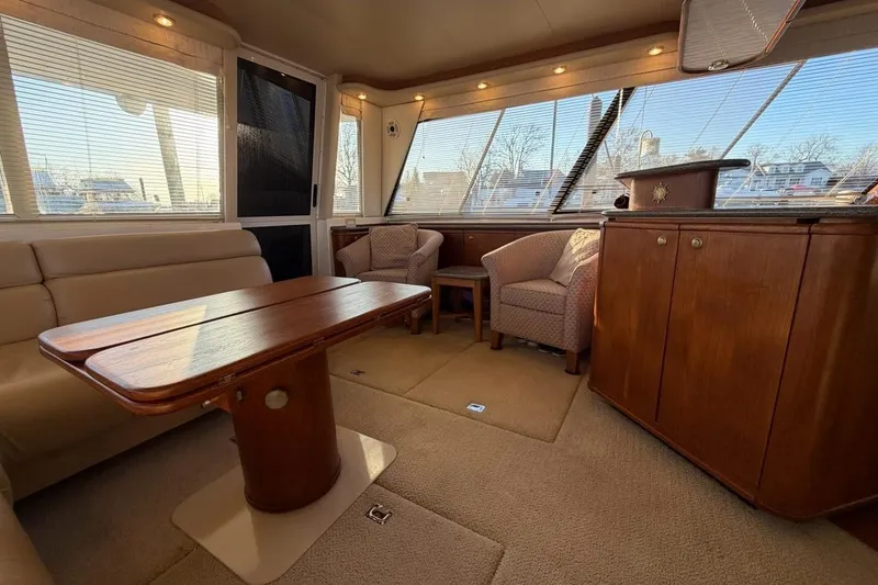 Slide: The Image of Luxurious interior of 1999 Bayliner 4788 Pilot House Motoryacht with elegant seating and wooden furnishings. - 15