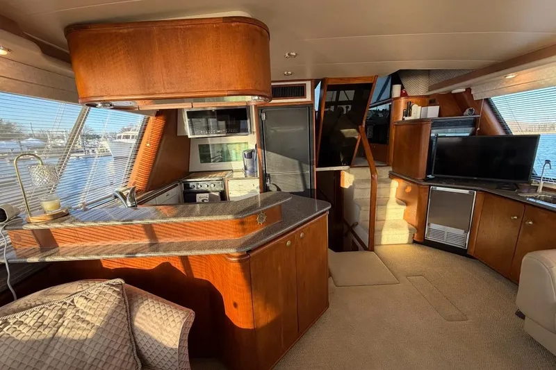 Slide: The Image of Luxurious interior of a 1999 Bayliner 4788 Pilot House Motoryacht with modern kitchen and cozy seating. - 18