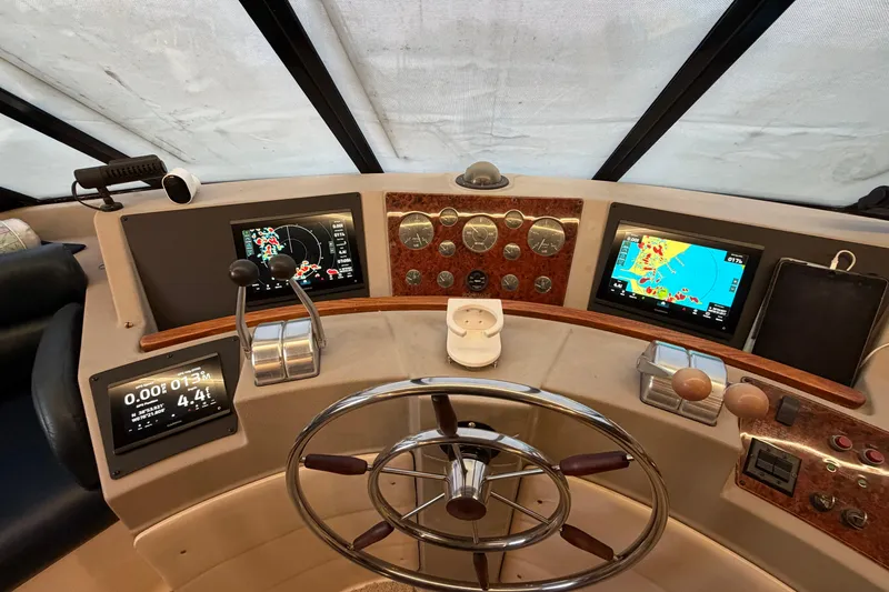 Slide: The Image of 1999 Bayliner 4788 Pilot House Motoryacht helm with navigation screens and controls. - 21