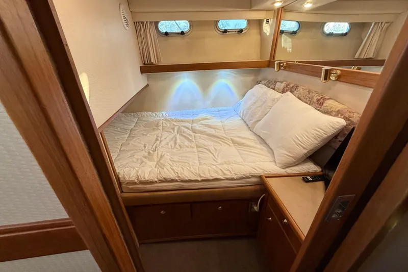 Slide: The Image of Cozy bedroom in 1999 Bayliner 4788 Pilot House Motoryacht with wood accents and natural light. - 26