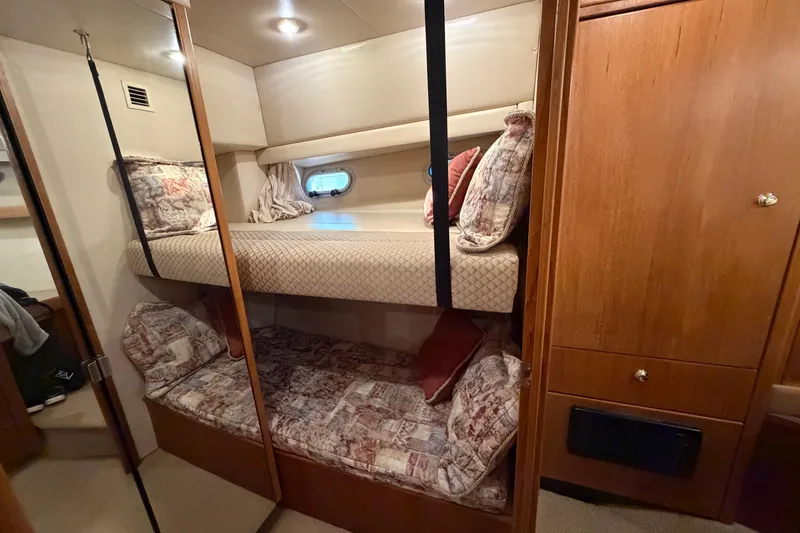 Slide: The Image of Interior of 1999 Bayliner 4788 Pilot House Motoryacht with cozy bunk beds and wooden cabinetry. - 33