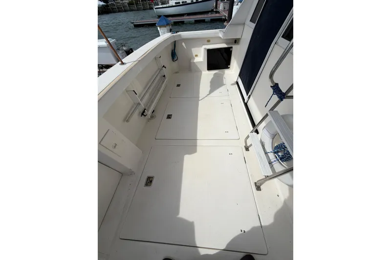 Slide: The Image of 1999 Bayliner 4788 Pilot House Motoryacht deck with storage compartments and ladder. - 5
