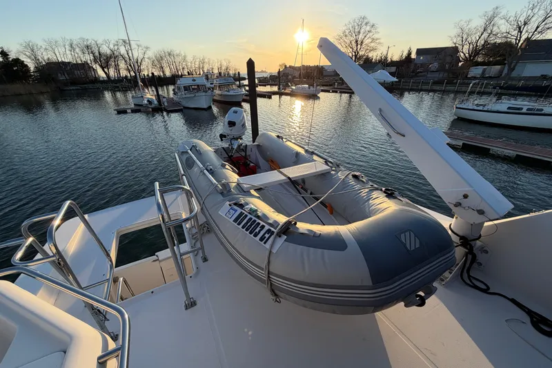 Slide: The Image of 1999 Bayliner 4788 Pilot House Motoryacht with inflatable boat at sunset in marina. - 6