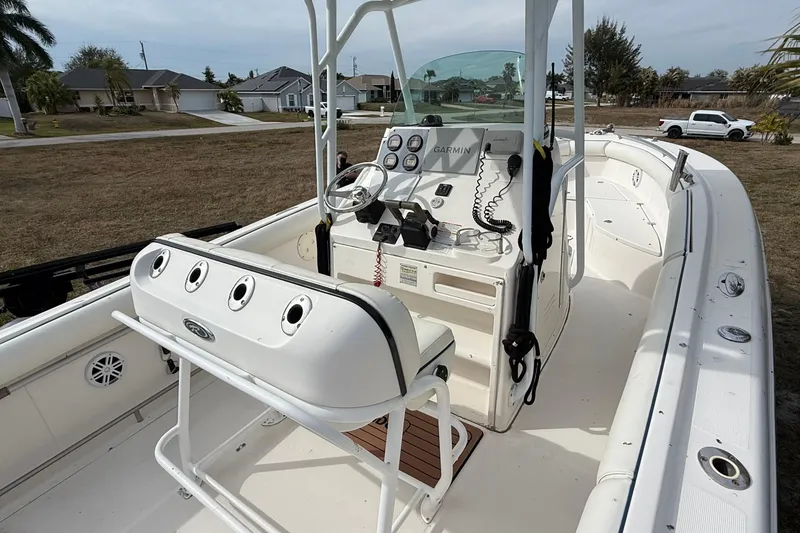 Slide: The Image of 2004 Rabalo 265 boat interior with steering console and seating, parked on grass. - 12