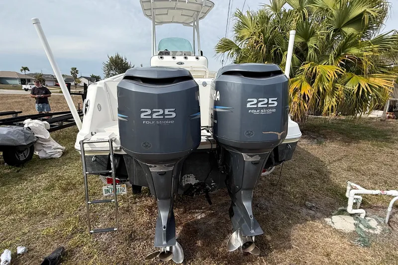 Slide: The Image of 2004 Rabalo 265 boat with twin Yamaha 225 four-stroke engines, parked outdoors. - 14