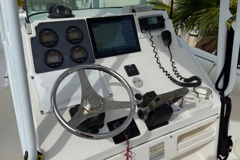 Slide: The Image of 2004 Rabalo 265 boat dashboard with steering wheel, gauges, and navigation equipment. - 3