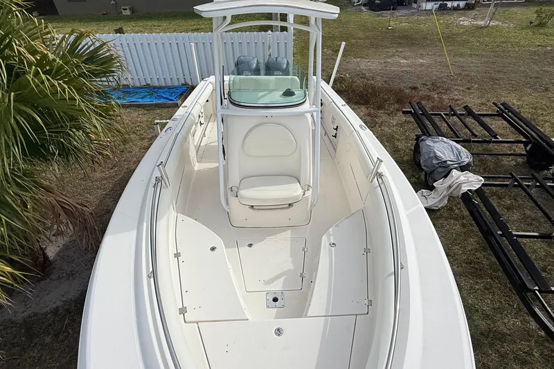 Slide: The Image of 2004 Rabalo 265 boat with white deck and center console, parked on grass. - 5