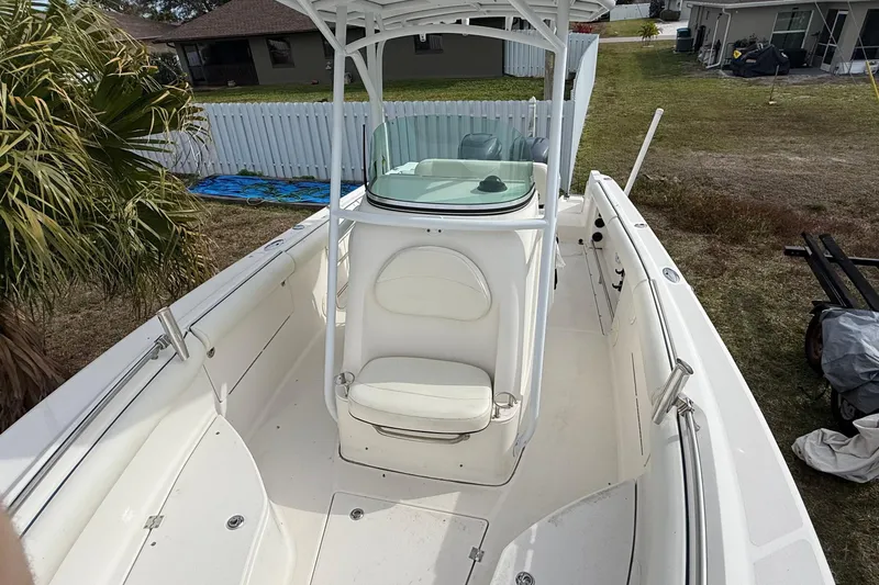 Slide: The Image of 2004 Rabalo 265 boat with white seating and center console, parked outdoors. - 6
