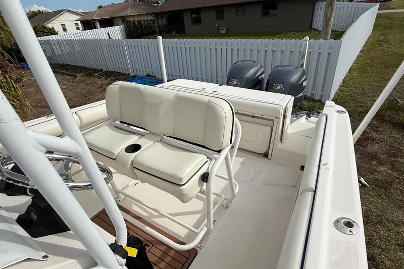 Slide: The Image of 2004 Rabalo 265 boat with dual Yamaha 225 engines, white seating, and fenced yard background. - 8