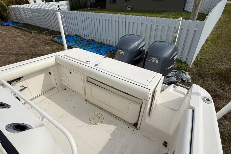 Slide: The Image of 2004 Rabalo 265 boat with dual Yamaha 225 engines, docked near a white fence. - 9