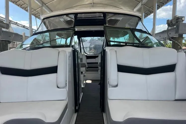 Slide: The Image of 2023 Four Winns H350 OB boat interior with white seating and glass windshield. - 15