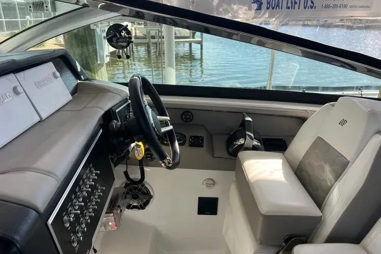 Slide: The Image of 2023 Four Winns H350 OB boat interior with steering wheel and control panel. - 17