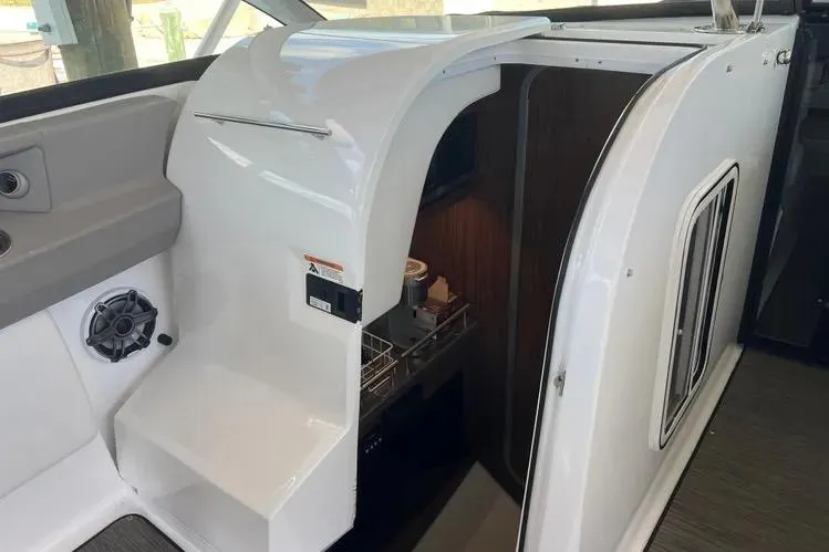 Slide: The Image of 2023 Four Winns H350 OB boat interior with sleek white cabinetry and modern amenities. - 21