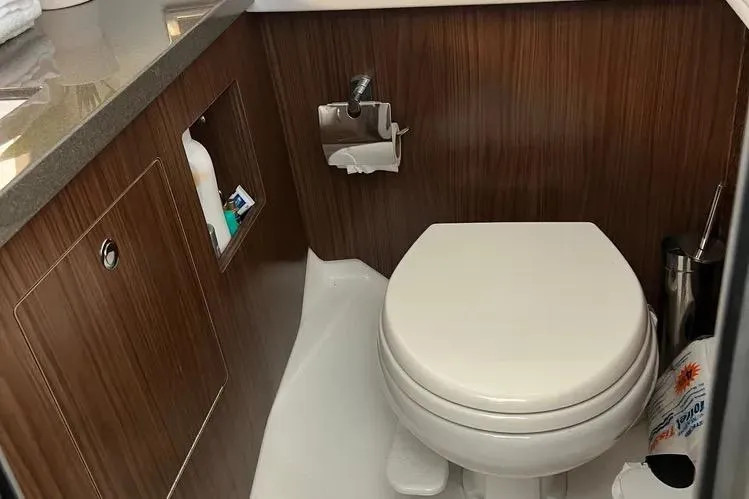 Slide: The Image of 2023 Four Winns H350 OB boat bathroom with wood paneling and modern fixtures. - 22