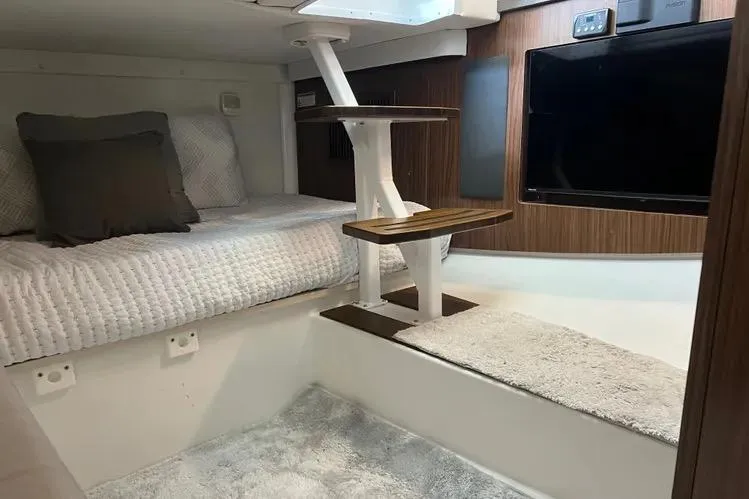 Slide: The Image of 2023 Four Winns H350 OB cabin interior with bed, stairs, and TV. - 23