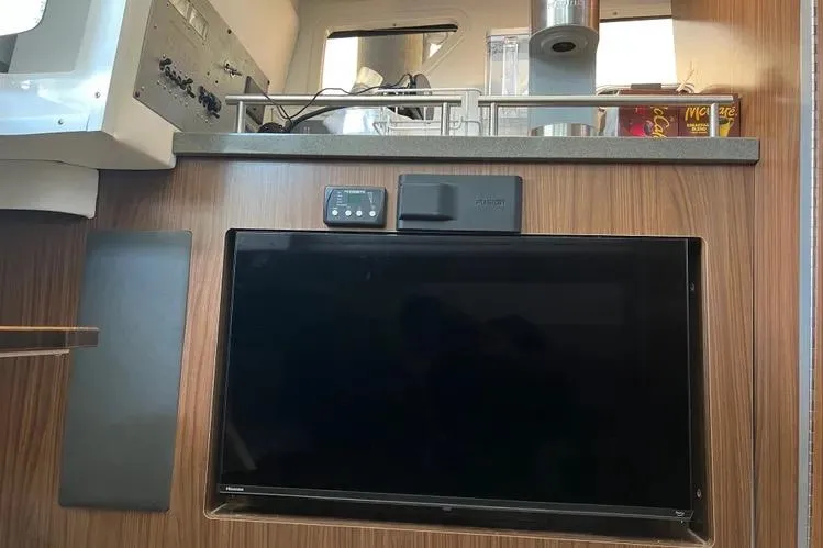 Slide: The Image of Interior of 2023 Four Winns H350 OB boat with mounted TV and control panel. - 26