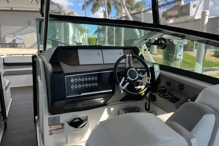 Slide: The Image of 2023 Four Winns H350 OB boat cockpit with modern steering and control panel. - 27