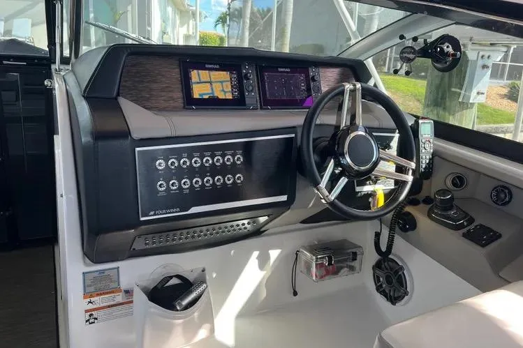 Slide: The Image of 2023 Four Winns H350 OB helm with advanced controls and navigation displays. - 28