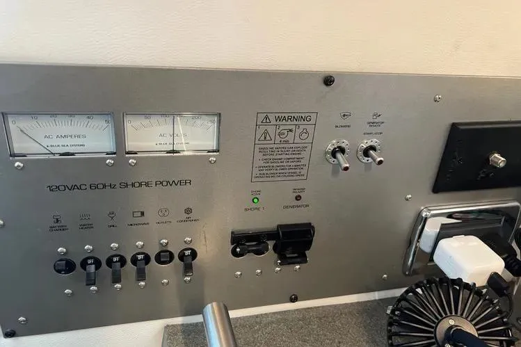 Slide: The Image of Control panel of 2023 Four Winns H350 OB boat with shore power indicators and switches. - 31