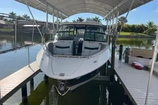 Slide: The Image of 2023 Four Winns H350 OB boat docked under a canopy on a sunny day. - 4