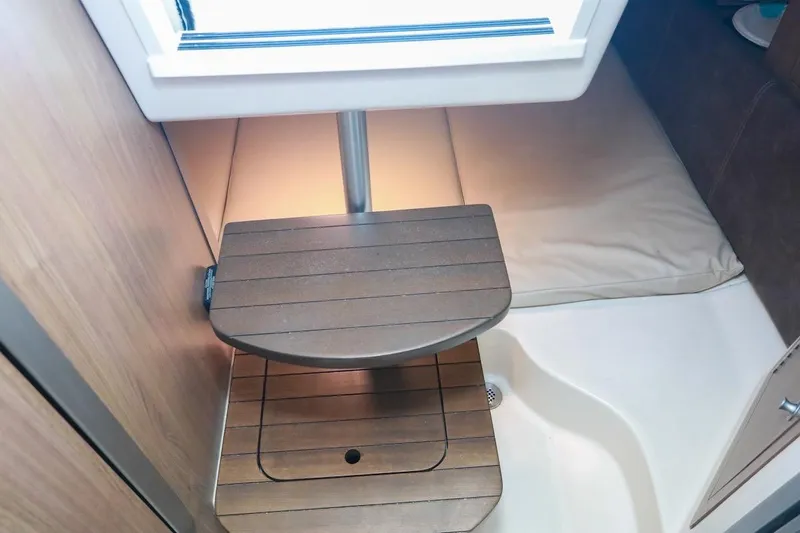 Slide: The Image of 2016 Boston Whaler 285 Conquest cabin interior with wooden steps and cushioned seating. - 14