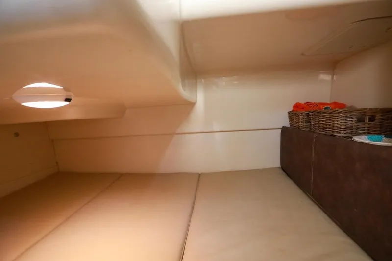 Slide: The Image of 2016 Boston Whaler 285 Conquest cabin interior with cozy bedding and storage baskets. - 15