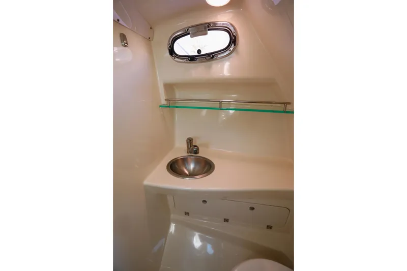 Slide: The Image of 2016 Boston Whaler 285 Conquest cabin interior with sink and porthole window. - 18