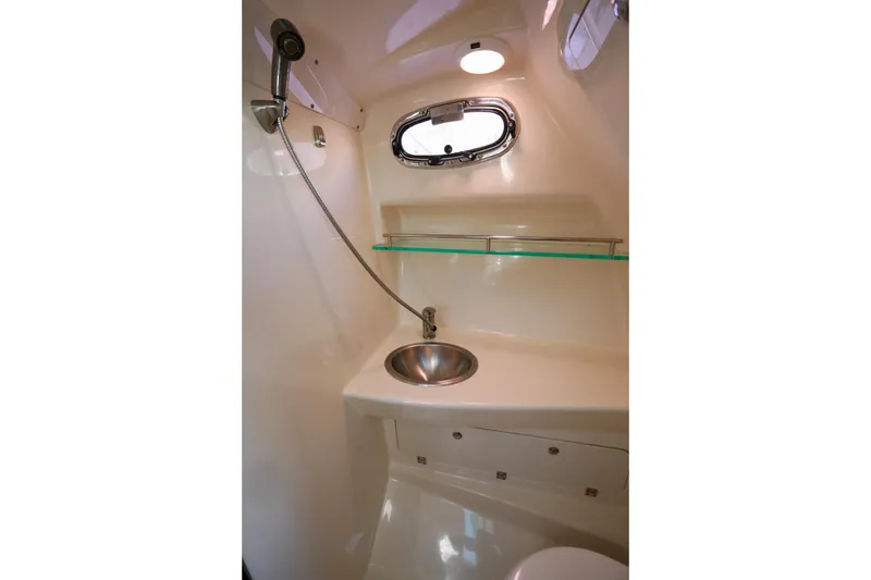 Slide: The Image of 2016 Boston Whaler 285 Conquest bathroom with sink, shower, and porthole window. - 19