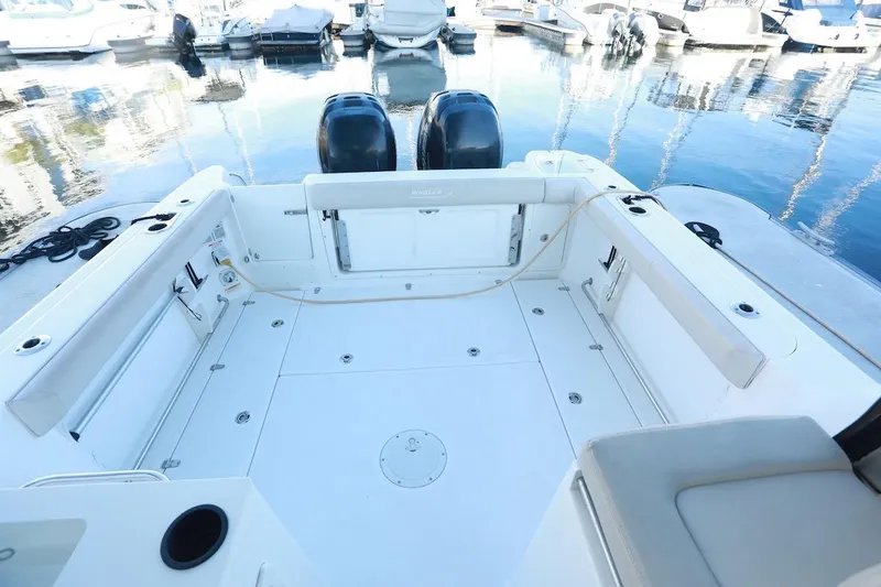 Slide: The Image of 2016 Boston Whaler 285 Conquest boat deck with twin engines at marina. - 3