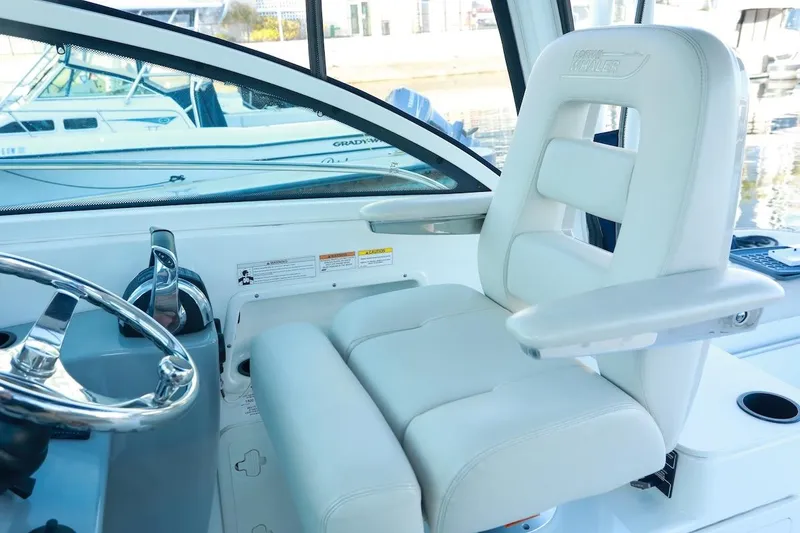 Slide: The Image of Captain's seat and helm of 2016 Boston Whaler 285 Conquest boat, featuring sleek design. - 4