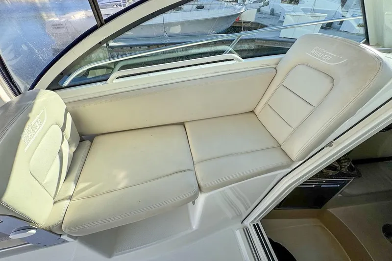 Slide: The Image of 2016 Boston Whaler 285 Conquest interior seating, featuring comfortable beige cushions. - 8