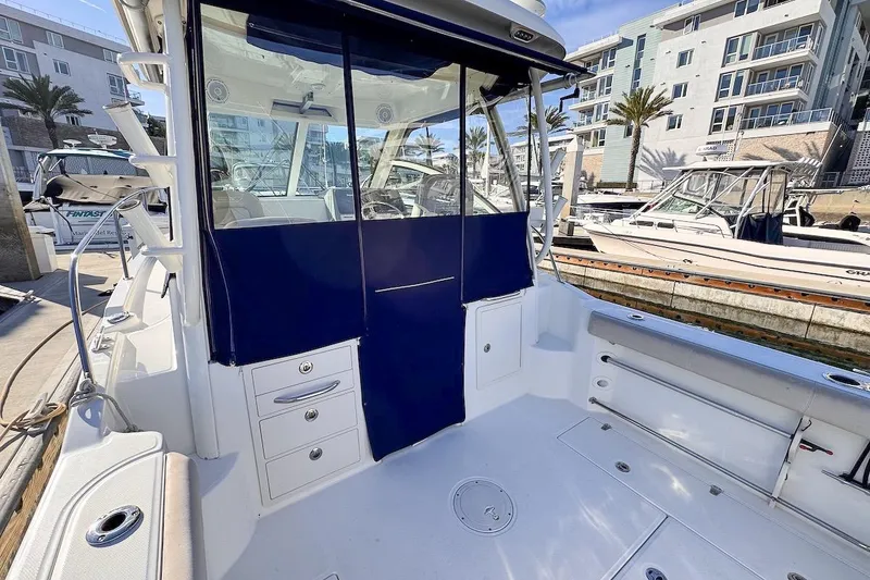 Slide: The Image of 2016 Boston Whaler 285 Conquest boat interior at marina, featuring seating and storage. - 9