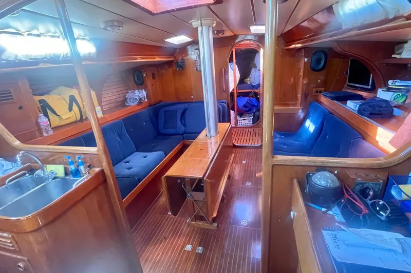 Slide: The Image of Interior of 1981 Nautor Swan cutter yacht with wooden finish and blue seating. - 11
