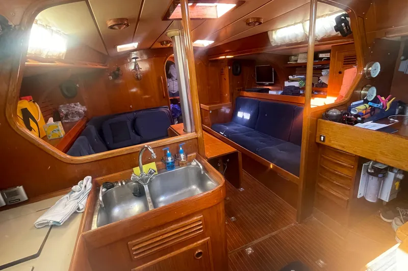 Slide: The Image of Interior of 1981 Nautor Swan cutter yacht, featuring wooden cabinetry and cozy seating area. - 13