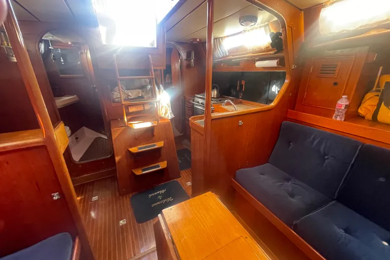 Slide: The Image of Interior of 1981 Nautor Swan cutter sailboat with wooden furnishings and cozy seating. - 14