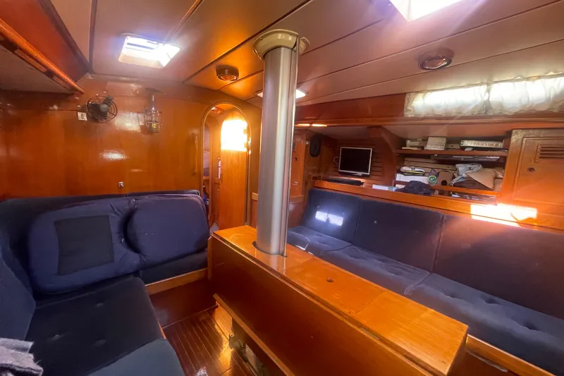 Slide: The Image of Interior of 1981 Nautor Swan cutter yacht with wooden finish and blue seating. - 15