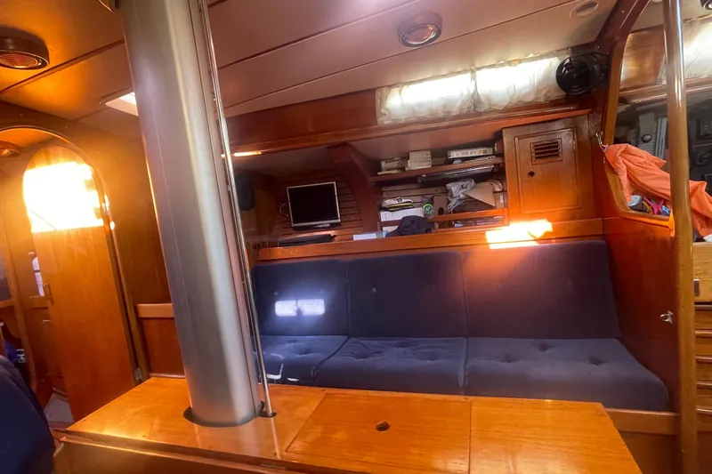 Slide: The Image of Interior of 1981 Nautor Swan cutter with wooden furnishings and cozy seating area. - 16