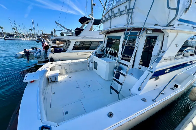 Slide: The Image of 1982 Bertram 46 Convertible yacht docked in a marina, showcasing spacious deck and sleek design. - 13