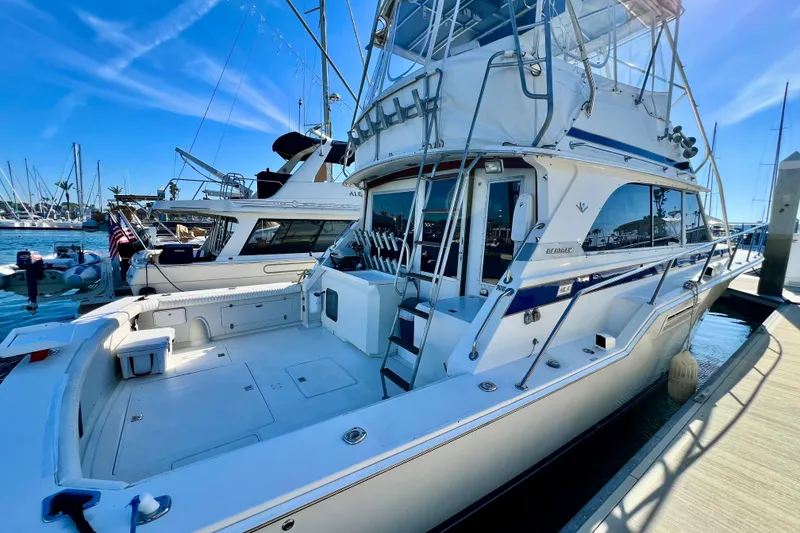 Slide: The Image of 1982 Bertram 46 Convertible yacht docked at marina under clear blue sky. - 14