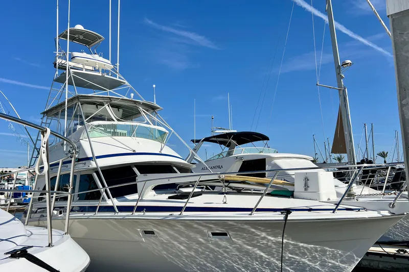 Slide: The Image of 1982 Bertram 46 Convertible yacht docked at marina under clear blue sky. - 15