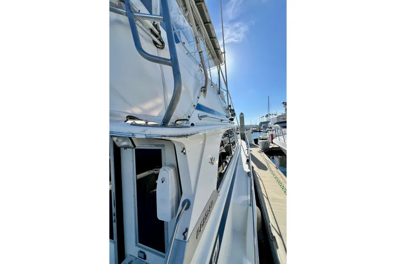 Slide: The Image of 1982 Bertram 46 Convertible yacht docked at marina under clear blue sky. - 16