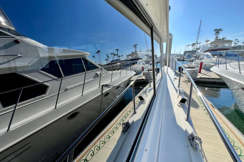 Slide: The Image of 1982 Bertram 46 Convertible yacht docked in a sunny marina, reflecting on calm water. - 17